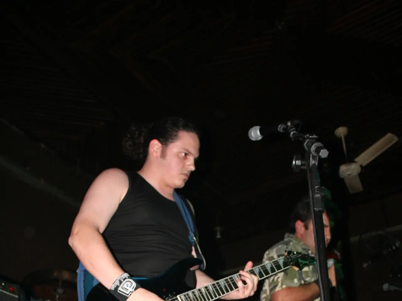 There are few people on the stage performing by playing musical instruments.