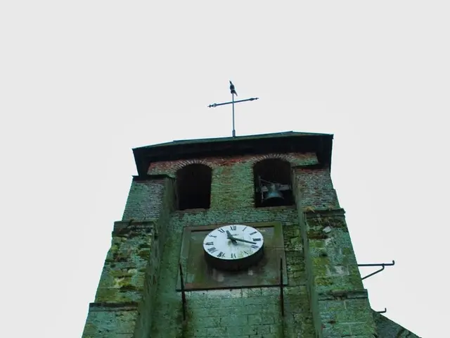 In this image we can able to see building with wall clock on it, there is a compass on top of it,...