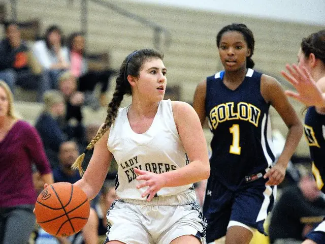 Here I can see few women wearing t-shirts, shorts and playing the volleyball on the floor. In the...