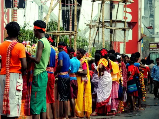 In the picture there are many people standing in a queue, they are collecting something and there...